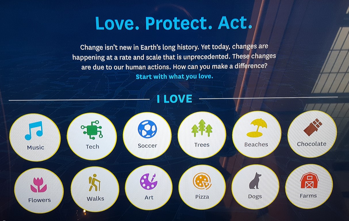 Image shows the face of an interactive touch screen with the words "Love. Protect. Act." and images you can click on, such as "music", "beaches", "walks", "art", "Dogs", etc. 